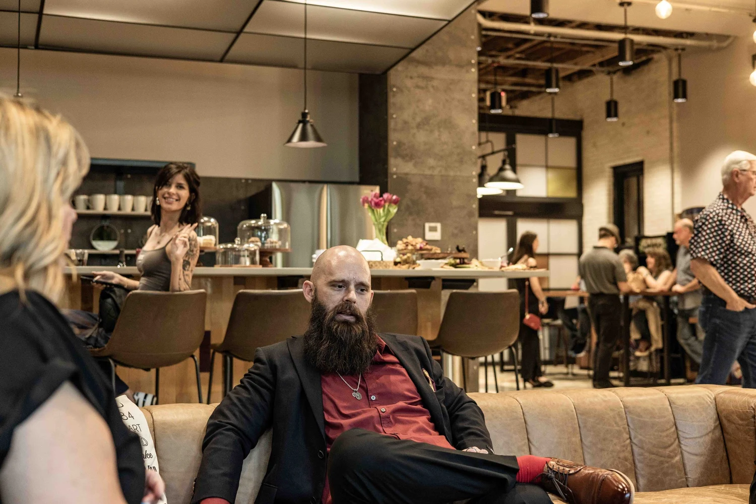People socializing in a cozy, modern restaurant or cafe with a bar area in the background.